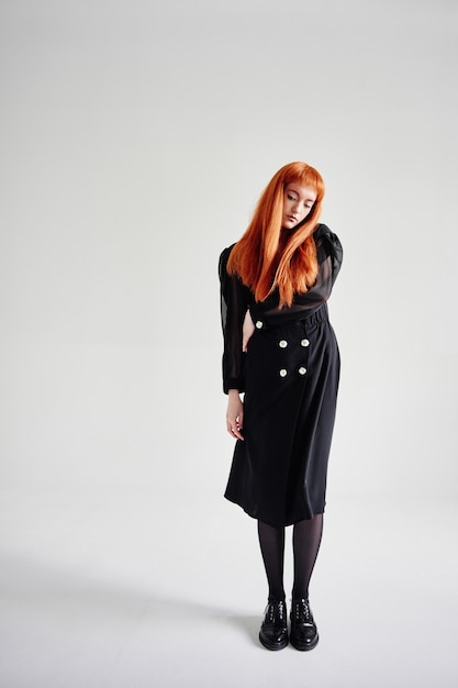 Fashion model in black clothes posing in Studio on white background