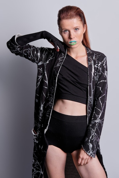 Fashion model in black coat with print and top and high waist briefs