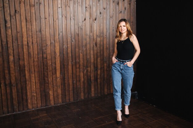 Fashion model in denim and black t-shirt in studio.