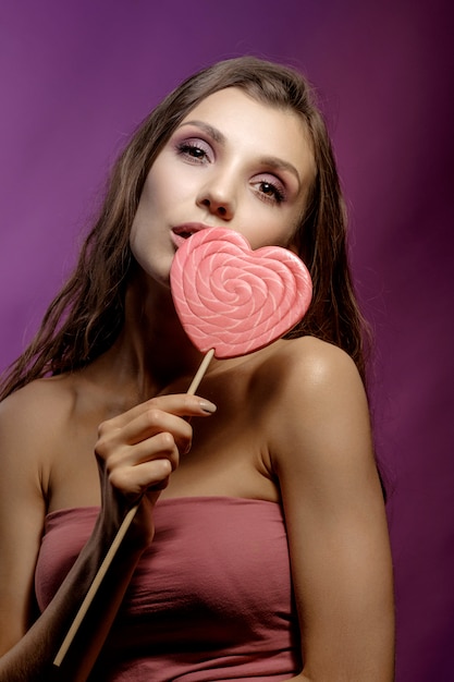 Photo fashion model girl with valentine heart, love concept, smiling young woman