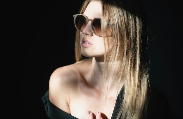 Модель в солнцезащитных очках с красивым лицом нежная женщина на черном темном фоне нежность
