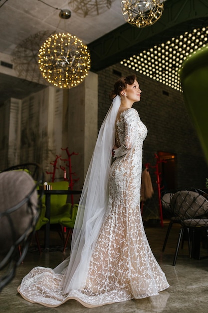 Fashion model with glamour look and makeup Sexy woman sit alone in street cafe Woman in white wedding dress outdoor Girl with long brunette hair Bride with makeup face