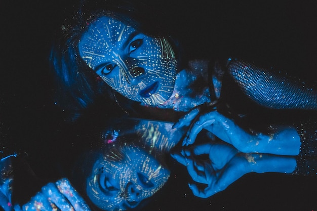 Foto modella donna in luce al neon ritratto di una bellissima modella con trucco artistico fluorescente cosplay per il film avatar la ragazza è un avatar