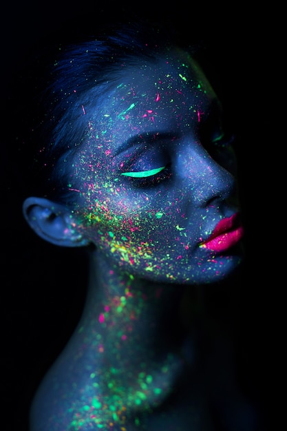 Donna del modello di moda con trucco fluorescente luminoso al neon