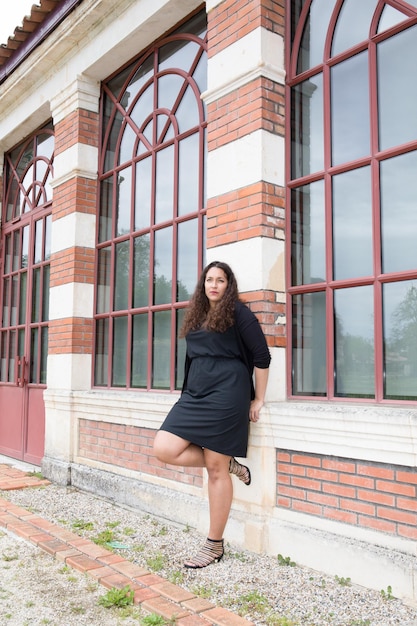 Fashion outdoor portrait of sensual brunette woman with black dr