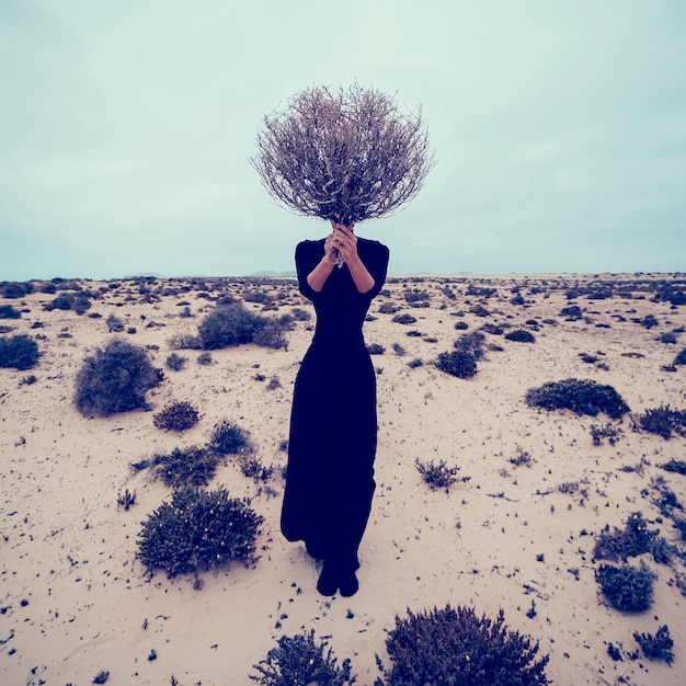 Foto foto di moda. ragazza nel deserto con un mazzo di rami secchi