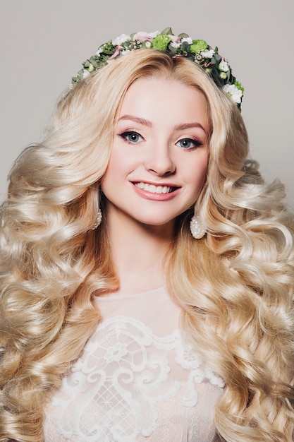 Fashion photo of young bride girl with long curly hair and floral wreath