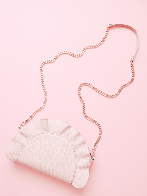 Фото Модная розовая женская сумочка на бледно-розовом фоне