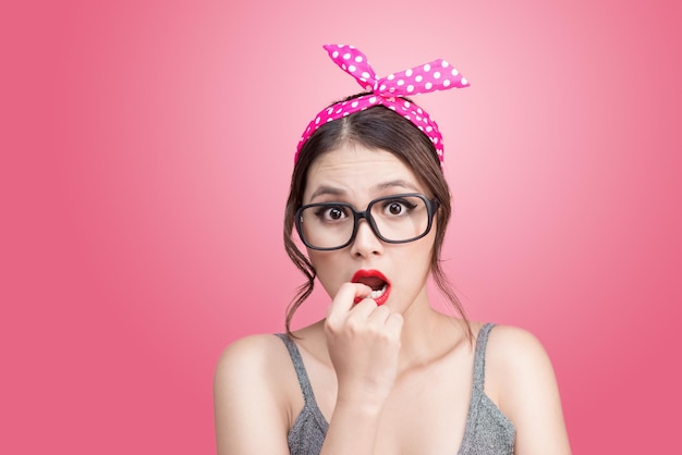 Fashion portrait of asian girl with sunglasses standing on pink background