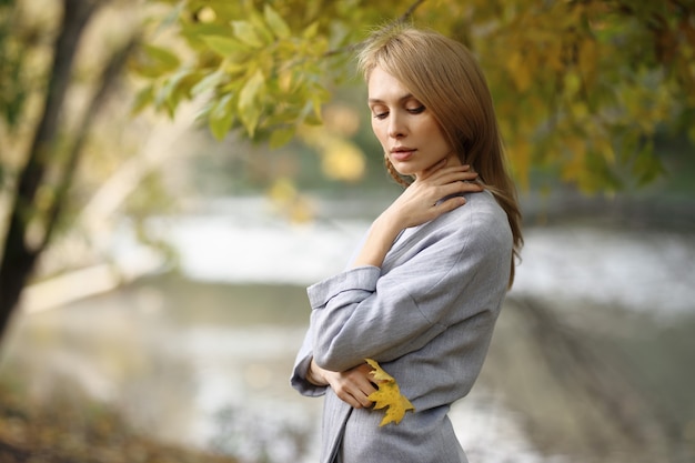 가을에 야외 세련 된 옷에 아름 다운 금발 여자의 패션 초상화.