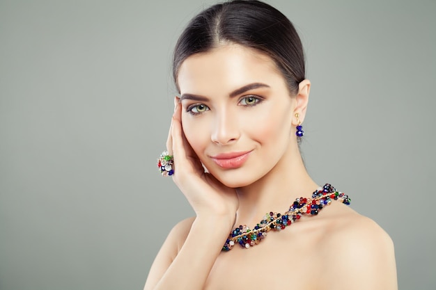 Fashion portrait of beautiful model woman with bright jewelry ring necklace and earrings