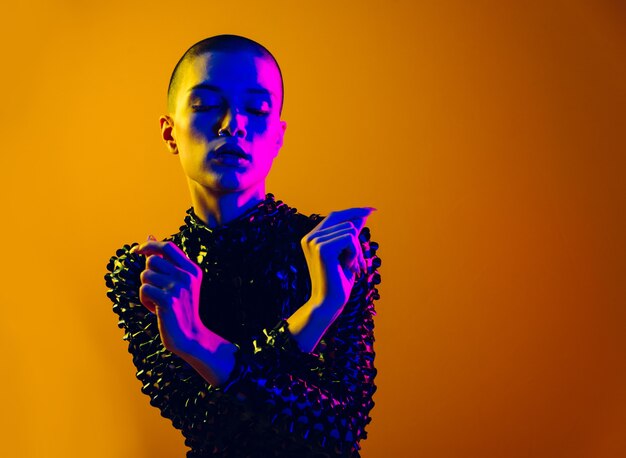 Fashion portrait of beautiful woman on colored wall