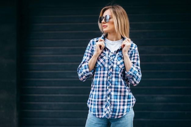 Fashion portrait of beautiful woman with beautiful face wearing grunge plaid shirt Posing alone