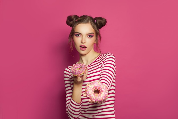 Photo fashion portrait of cute woman with donuts on colorful pink background