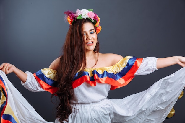 회색 배경에 고립 된 예쁜 콜롬비아 여자 춤의 패션 초상화