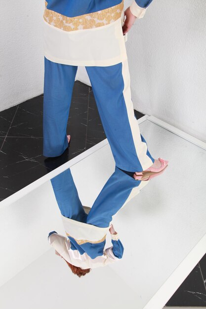 Photo fashion portrait of ginger woman in fashionable stylish summer suit standing on mirror studio