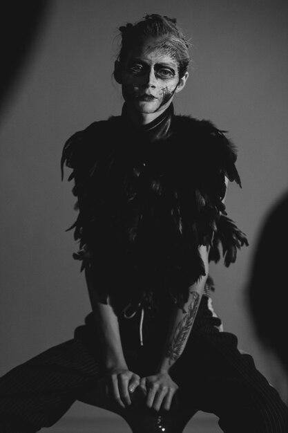 Fashion portrait of girl in conceptual make up and clothes against gray background in studio