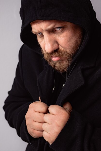 Photo fashion portrait handsome elegant bearded man wearing black coat with hood