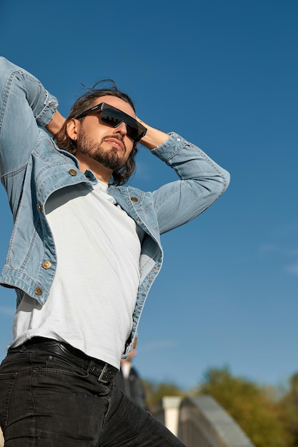 Fashion portrait of handsome elegant man with curly hair wearing sunglasses outdoor