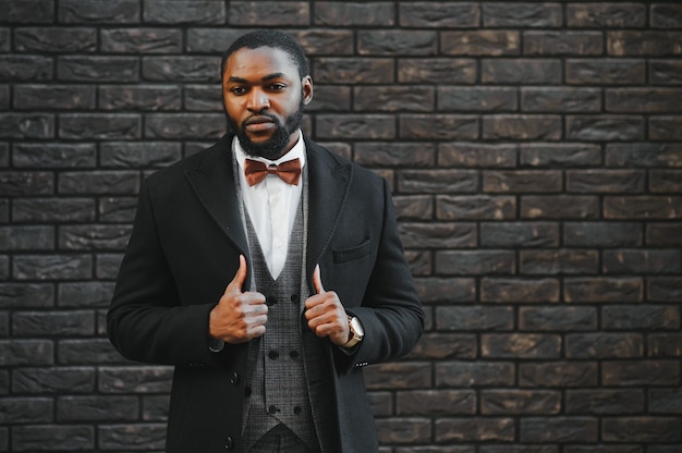 Fashion portrait of a handsome young African American business man walking outdoors in a casual pose