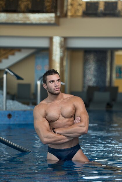Фото Модный портрет очень мускулистого сексуального мужчины в нижнем белье у бассейна