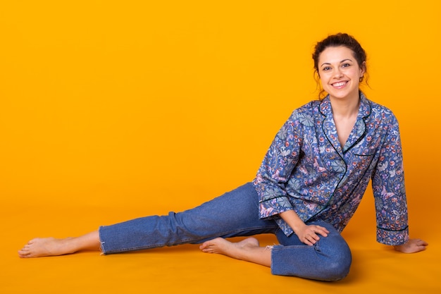 Fashion portrait pretty cool girl having fun over colorful yellow wall.