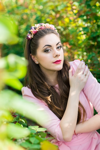 Fashion portrait of woman in dress among the flowers