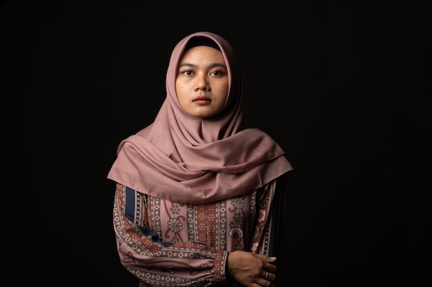 Fashion portrait of young beautiful asian muslim woman with\
wearing hijab on black background