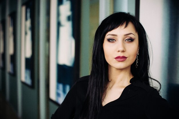 Fashion portrait of young beautiful woman in black dress.