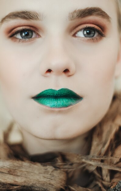 Fashion portrait of Young blond woman.Beautiful Girl with green lips. Concept Mother Nature