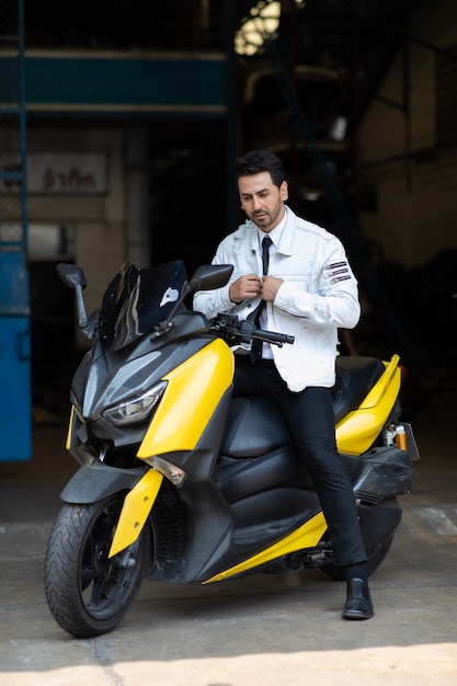 Fashion portrait young handsome guy posing on motorbike