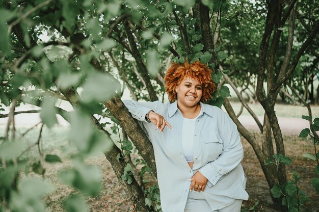 Fashion portrait of young naturally beautiful plus size african american woman in light trouser suit