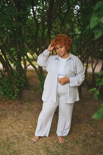 Fashion portrait of young naturally beautiful plus size african american woman in light trouser suit