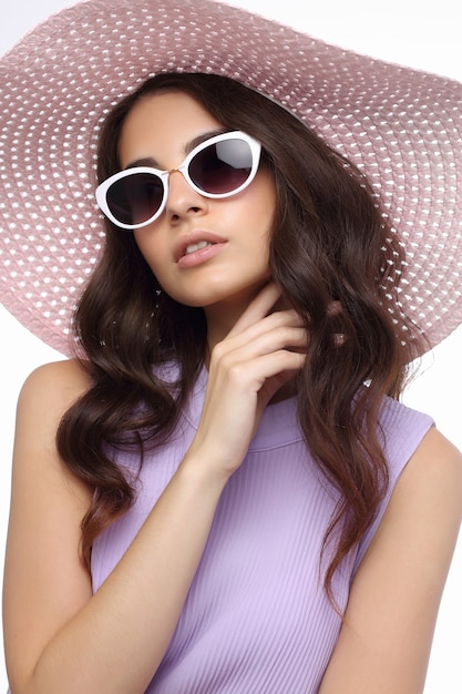 Fashion portrait of young woman wearing hat and sunglasses.