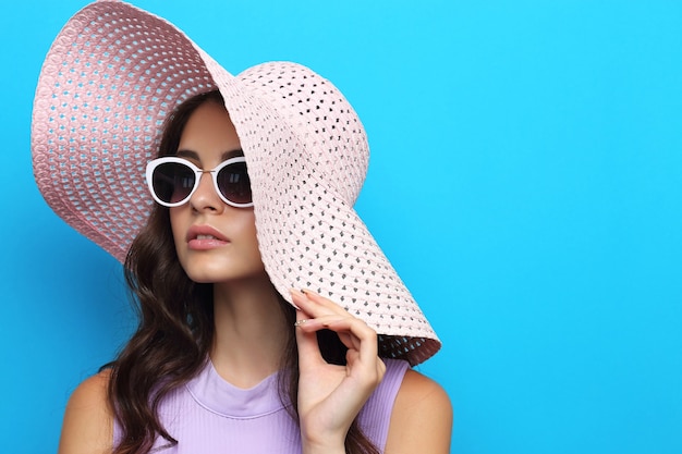 Fashion portrait of young woman wearing hat and sunglasses.