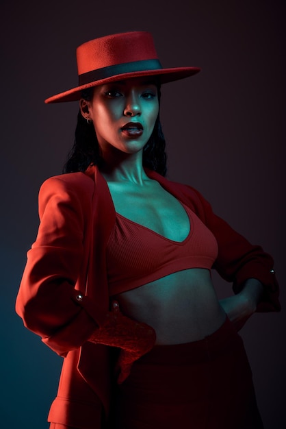 Fashion red aesthetic and woman in dark studio with neon background in trendy stylish and cool outfit Beauty creative style and portrait of female model with luxury designer and retro clothes
