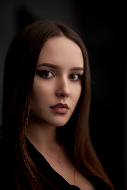  fashion shoot of brunette woman on dark wall