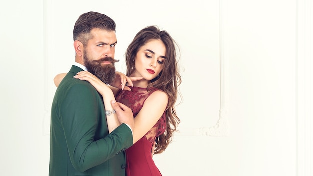 Foto colpo di moda. foto di moda di bell'uomo elegante in tuta con bella donna sexy in posa. coppia appassionata sessuale in abiti da sera eleganti. la donna si sente salva tra le braccia dell'uomo. interni lussuosi