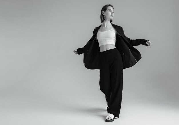 Fashion shot of stylish vogue woman in black suit in studio