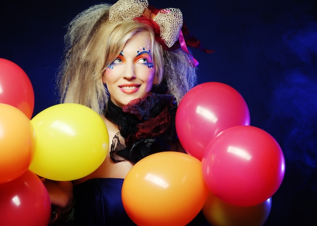 Fashion shot of woman in doll style with balloons. Creative make-up.