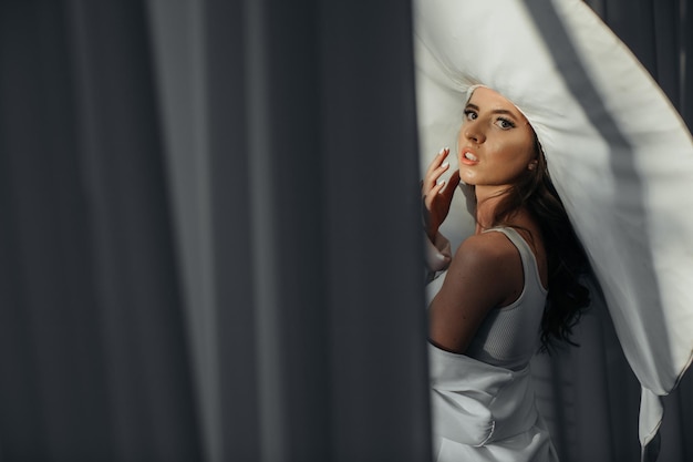 Foto foto in studio di moda di una signora elegante con un cappello bianco gigante salute e bellezza