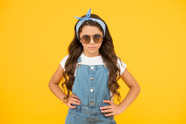 Photo fashion trend. you can have anything you want in life if dress for it. little fashionista. cute kid fashion girl. summer fashion concept. girl long curly hair wear sunglasses and fancy tied headscarf.