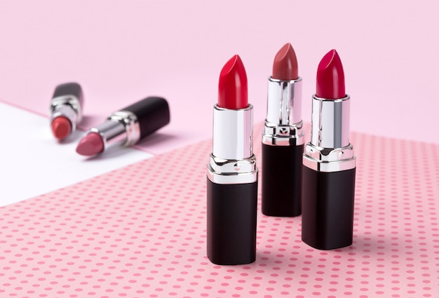 Fashion Trendy Colorful Lipsticks over pink table.