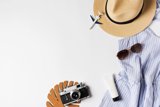 Appartamento per vacanze di moda con occhiali da sole e altri accessori in paglia blu su sfondo bianco vista dall'alto