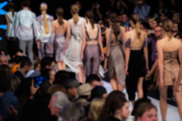 Foto fotografia a tema della settimana della moda di modelle che camminano il finale della sfilata di moda sfocato di proposito