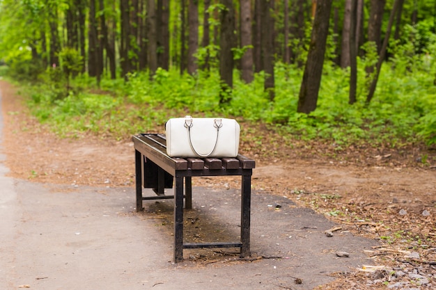 Photo fashion white bag on the bench outdoor