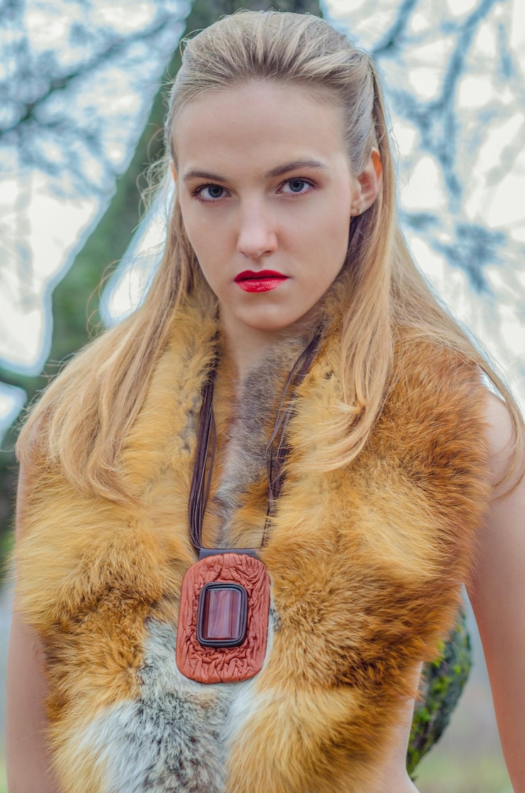Photo fashion wild huntress woman in fashion fur red lips make-up and a massive decoration jeweler