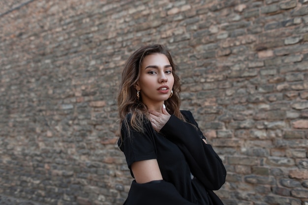 Fashion woman in black clothes walks on the street