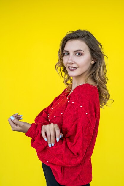 Fashion woman in classic red knitted sweater posing and smiling