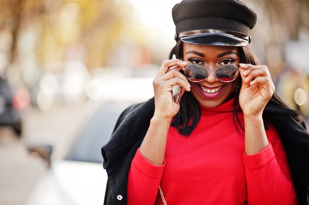 Fashion woman in coat, newsboy cap and sunglasses